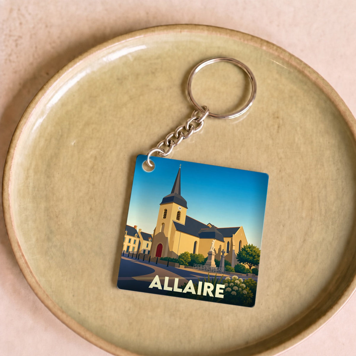 Porte-clés souvenir de la ville d'Allaire avec une illustration stylisée de son église.