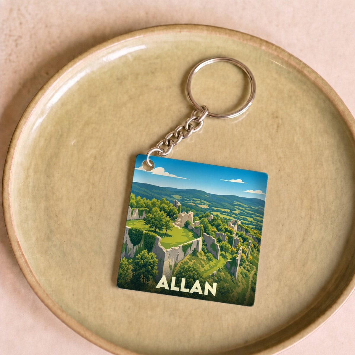 Porte-clés souvenir de la ville de Allan avec une illustration stylisée d'un château en ruines.