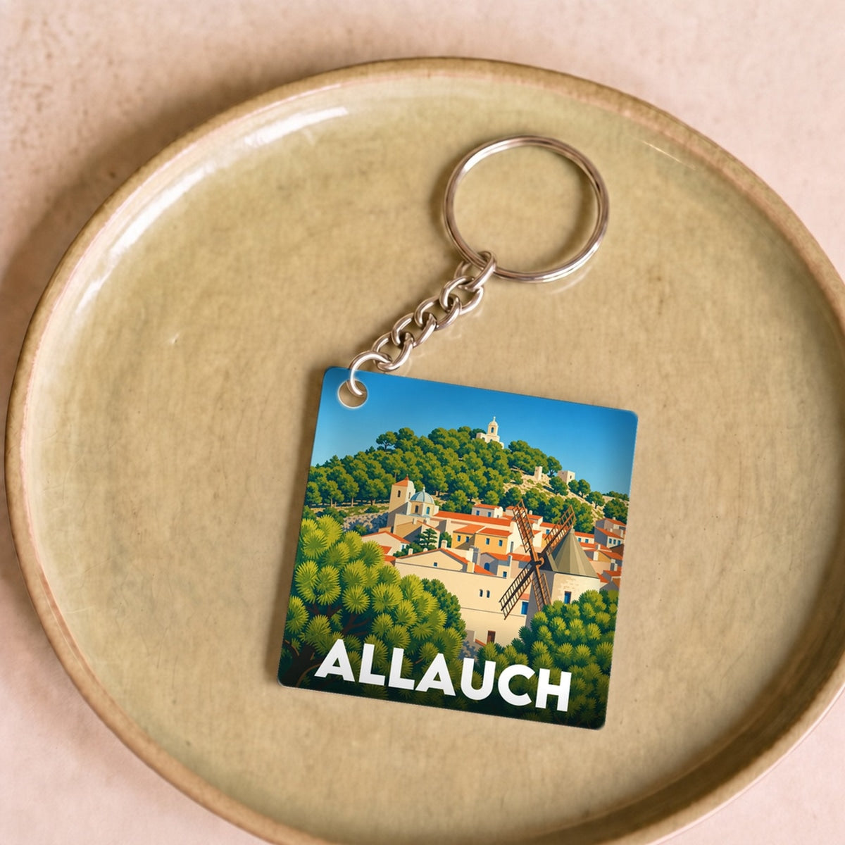 Porte-clés souvenir de la ville d'Allauch avec une illustration stylisée.