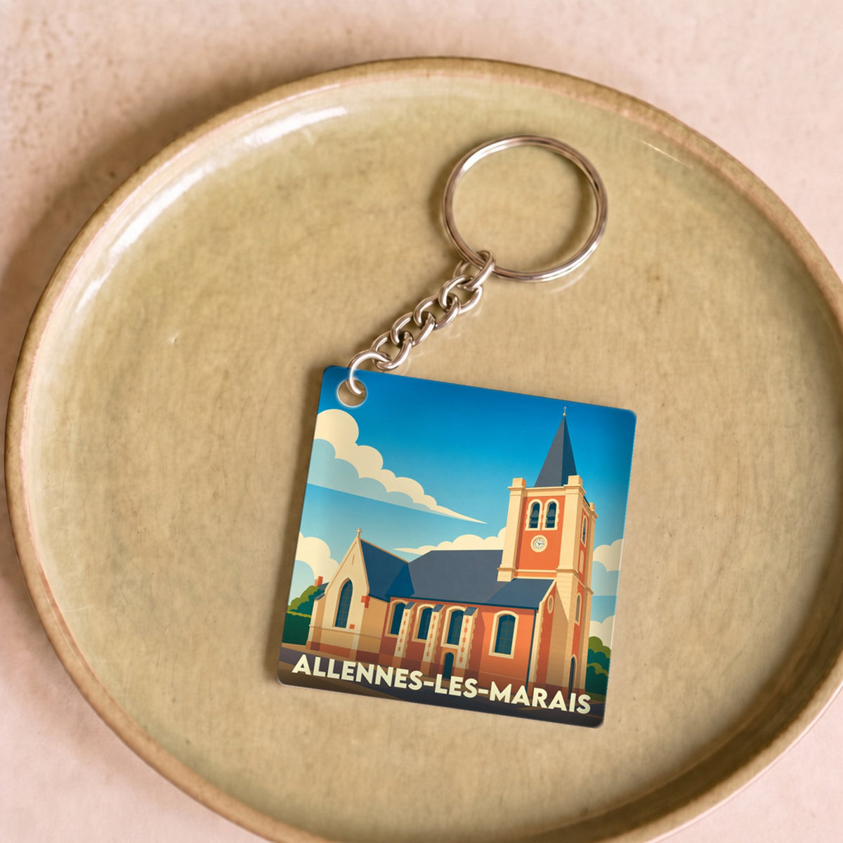 Porte-clés souvenir de la ville d'Allennes-les-Marais avec une illustration stylisée de son église.