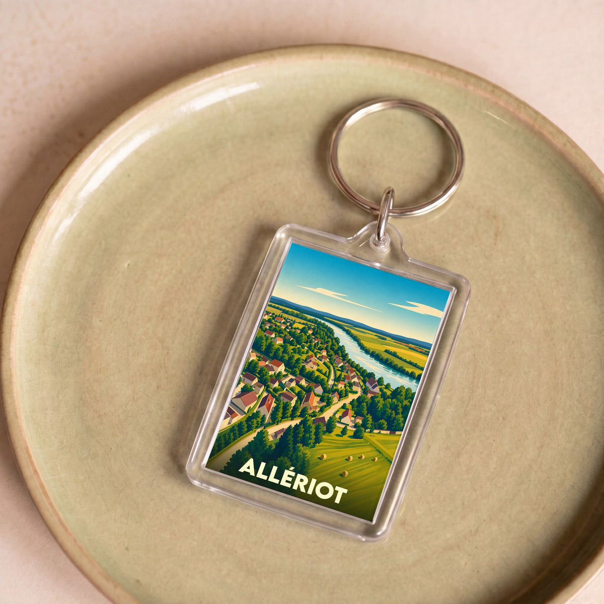 Porte-clés souvenir de la ville d'Allériot avec une illustration paysagère stylisée.