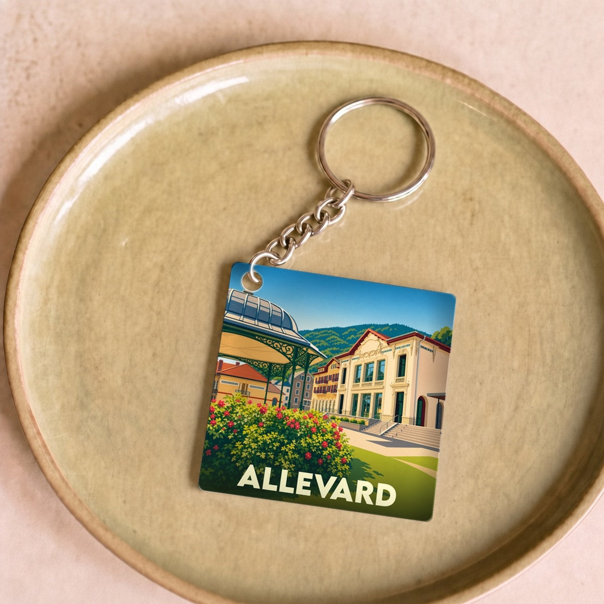 Porte-clés souvenir de la ville d'Allevard avec une illustration stylisée.