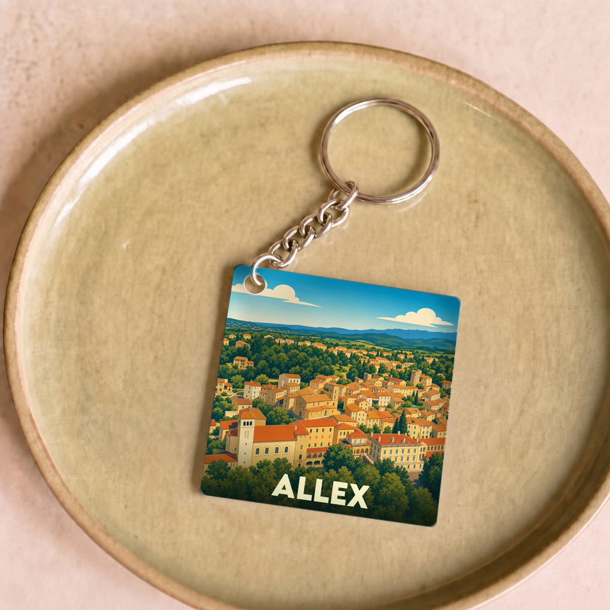 Porte-clés souvenir de la ville d'Allex avec une illustration stylisée de ses paysages.