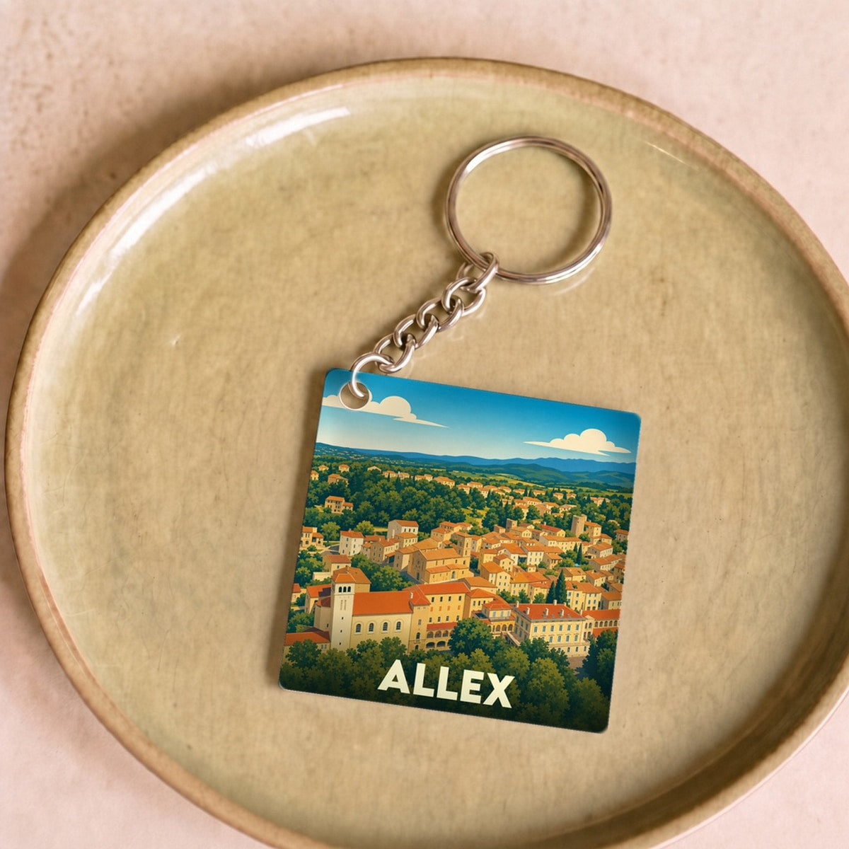 Porte-clés souvenir de la ville d'Allex avec une illustration stylisée de ses paysages.