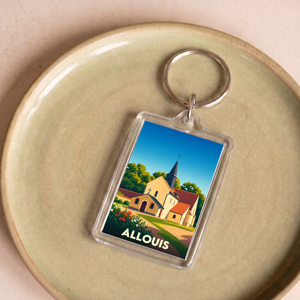 Porte-clés souvenir de la ville de Allouis avec une illustration stylisée de son église.