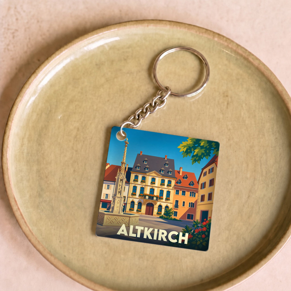 Porte-clés souvenir de la ville d'Altkirch avec une illustration stylisée et colorée de sa place historique.