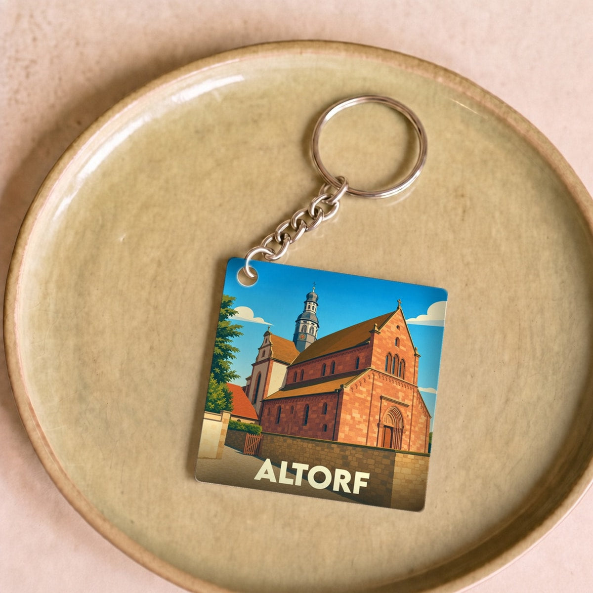 Porte-clés souvenir de la ville d'Altorf avec une illustration stylisée de son église abbatiale.