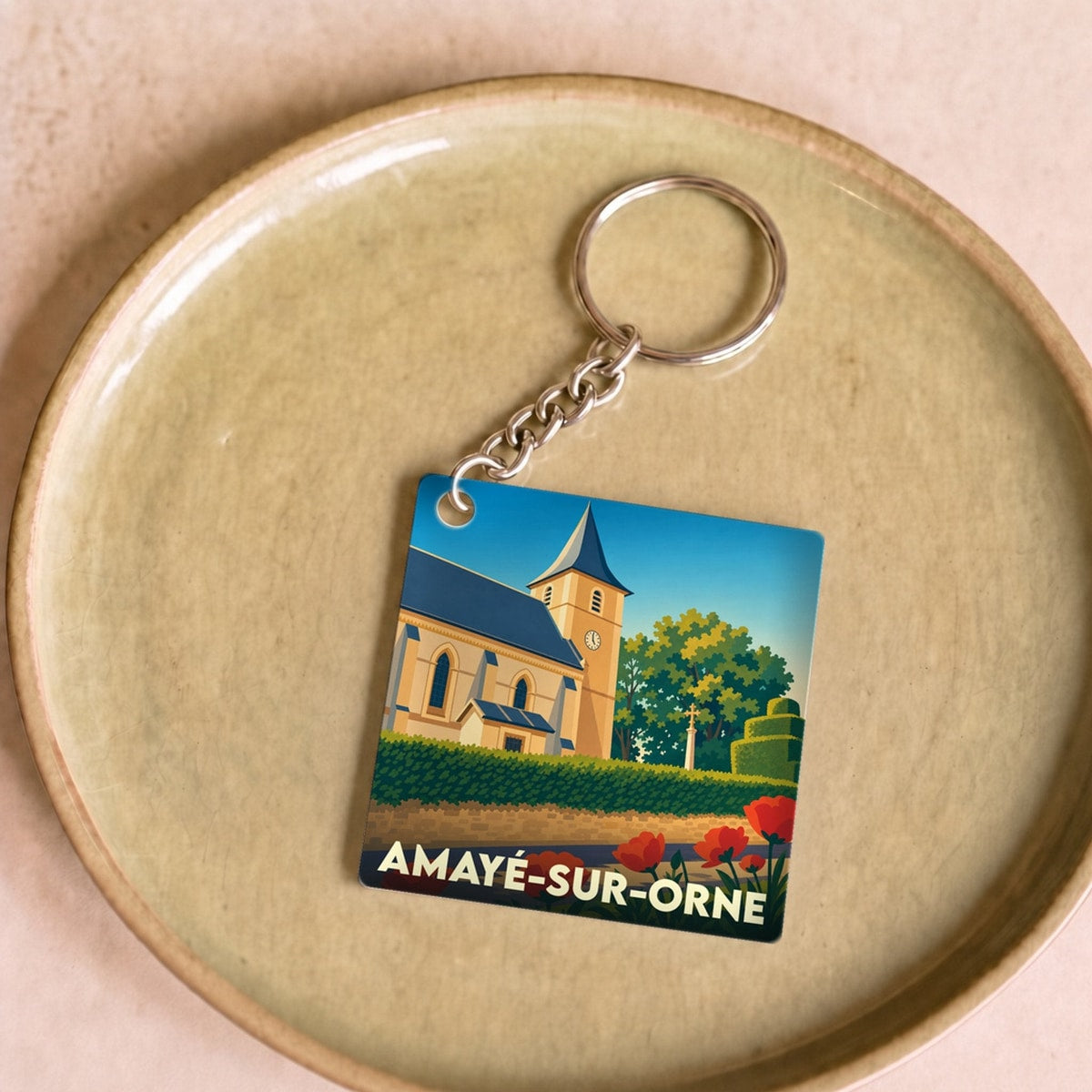 Porte-clés souvenir de la ville d’Amayé-sur-Orne avec une illustration stylisée de son église.