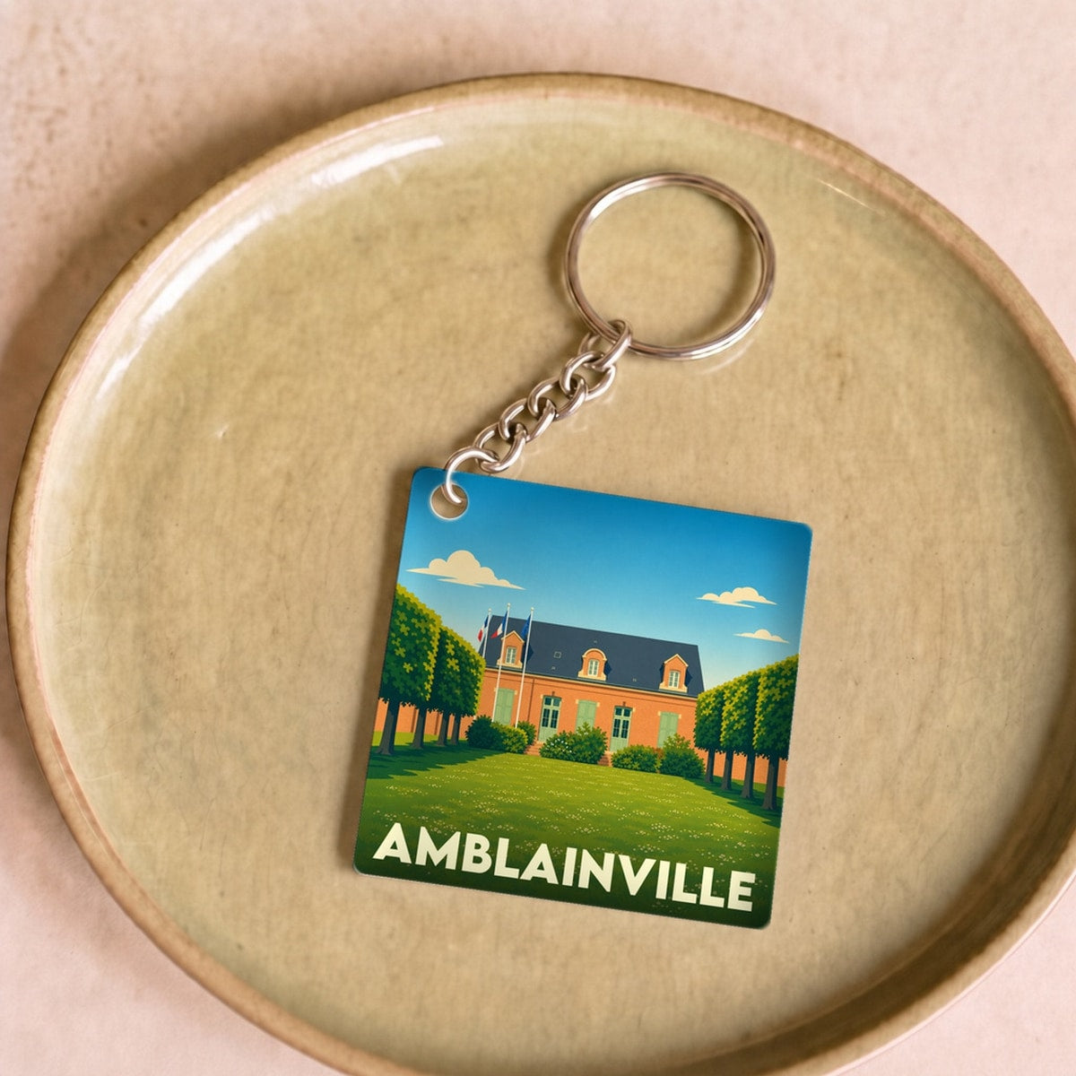 Porte-clés souvenir de la ville d'Amblainville avec une illustration stylisée de sa mairie.
