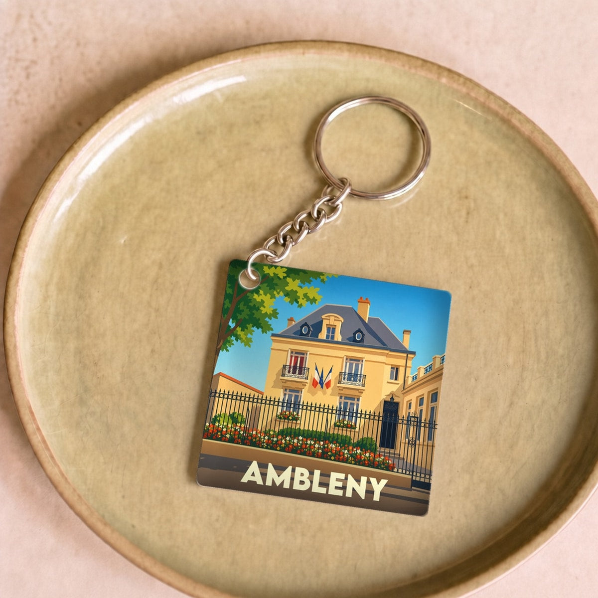 Porte-clés souvenir de la ville d'Ambleny avec une illustration stylisée.