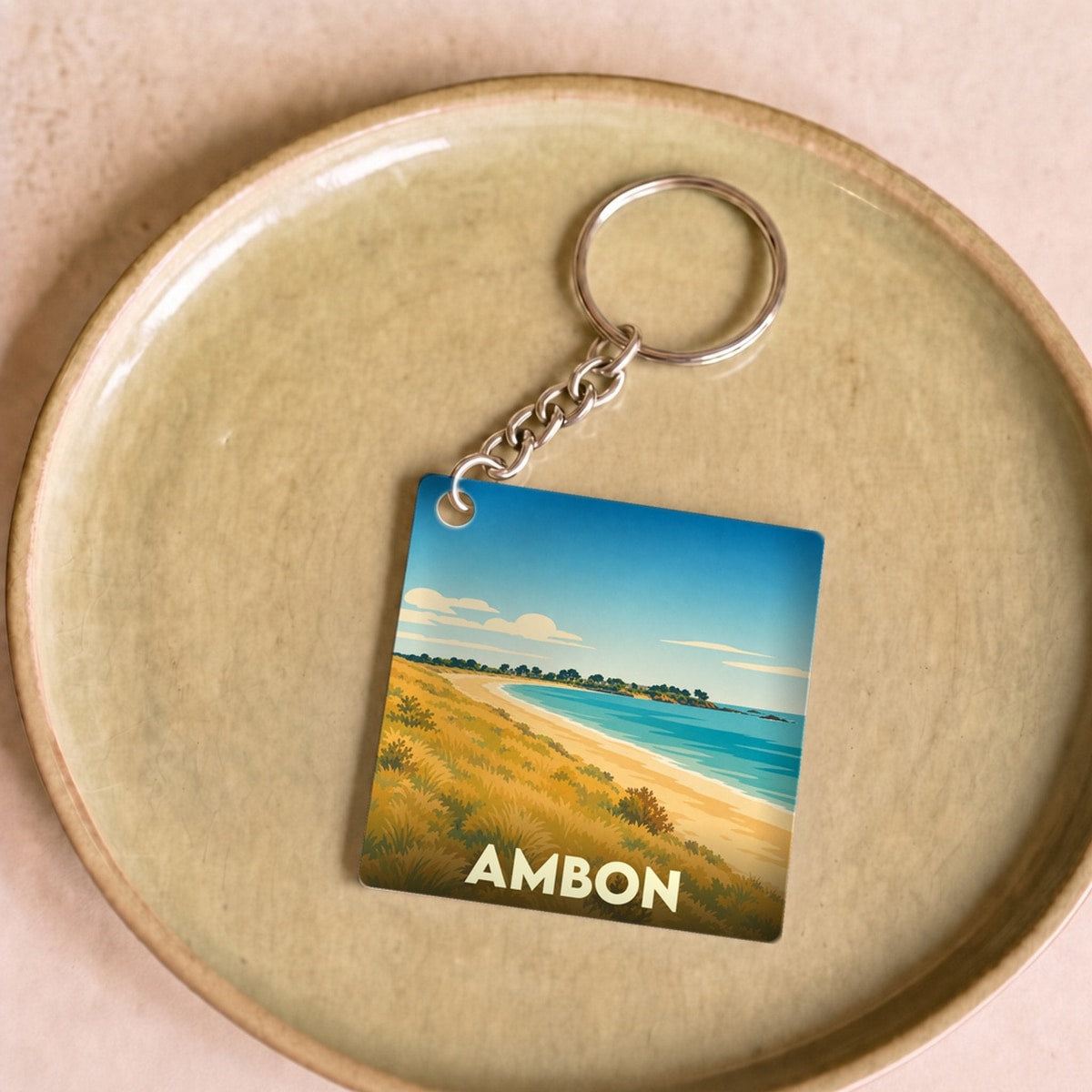 Porte-clés souvenir de la ville d'Ambon avec une illustration stylisée d'un paysage côtier.