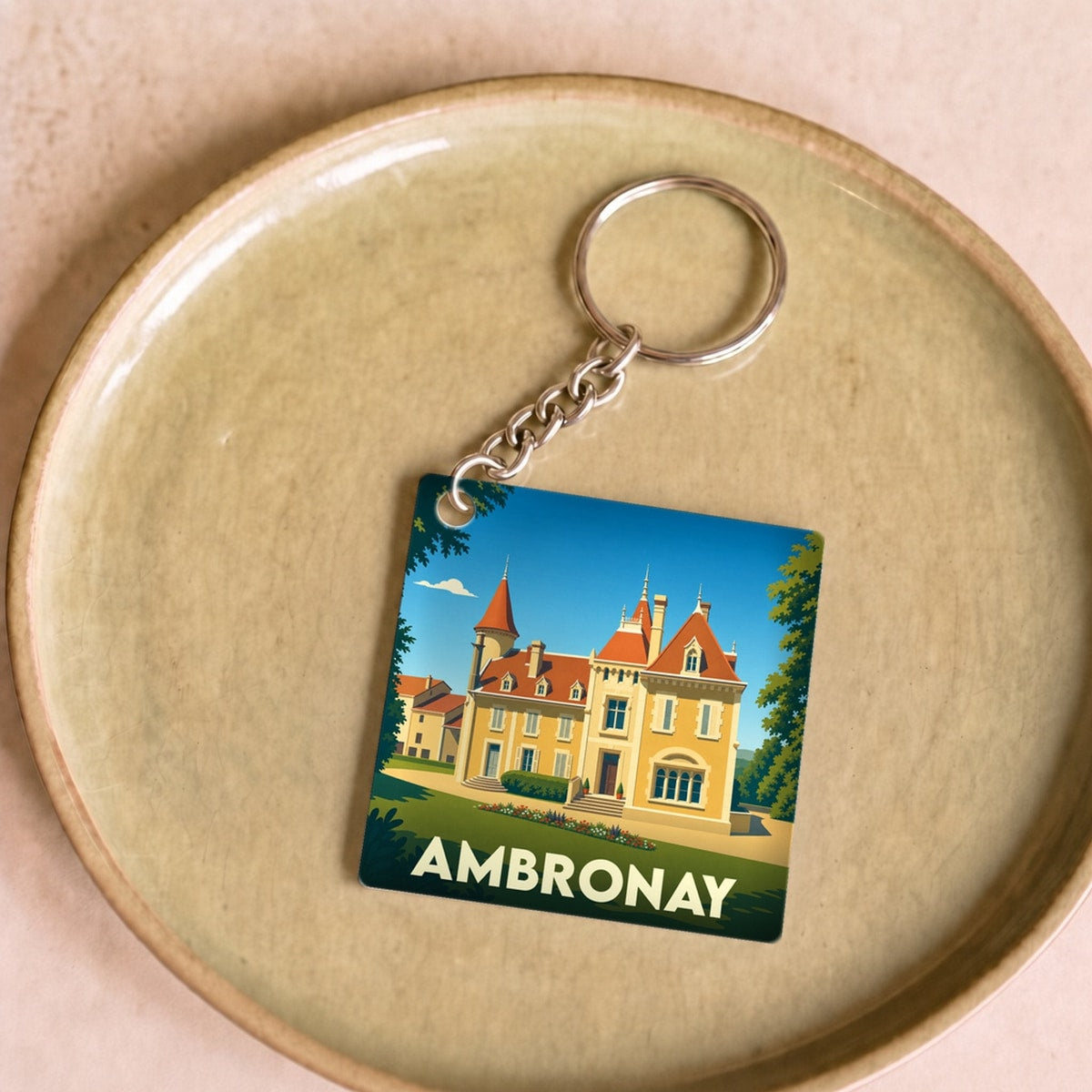 Porte-clés souvenir de la ville d'Ambronay avec une illustration stylisée d'un château.