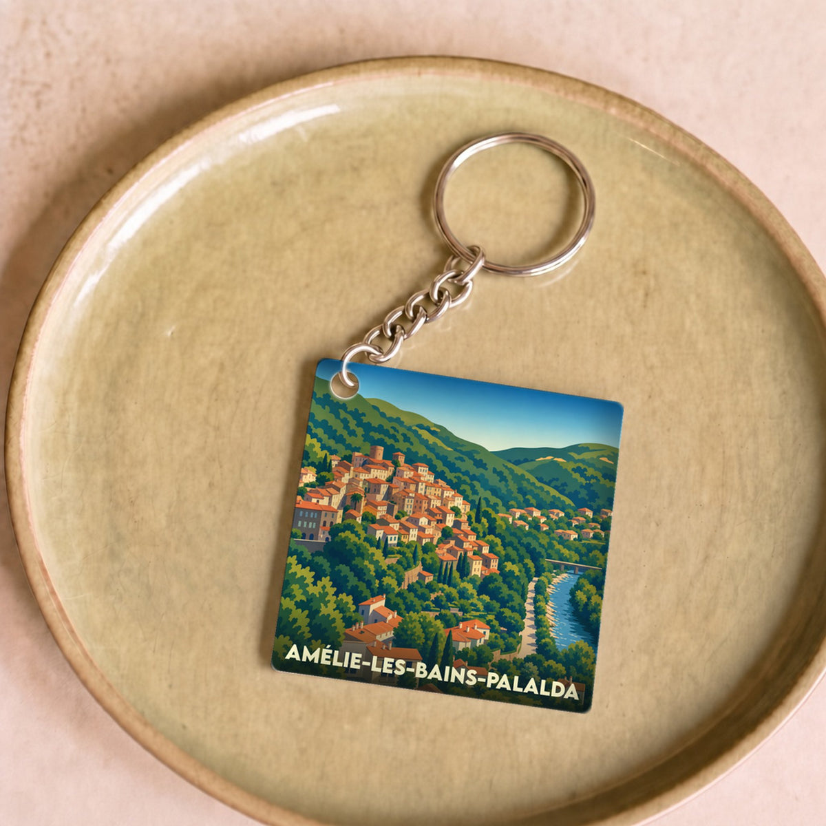 Porte-clés souvenir de la ville d'Amélie-les-Bains-Palalda avec une illustration stylisée de ses maisons colorées à flanc de colline.