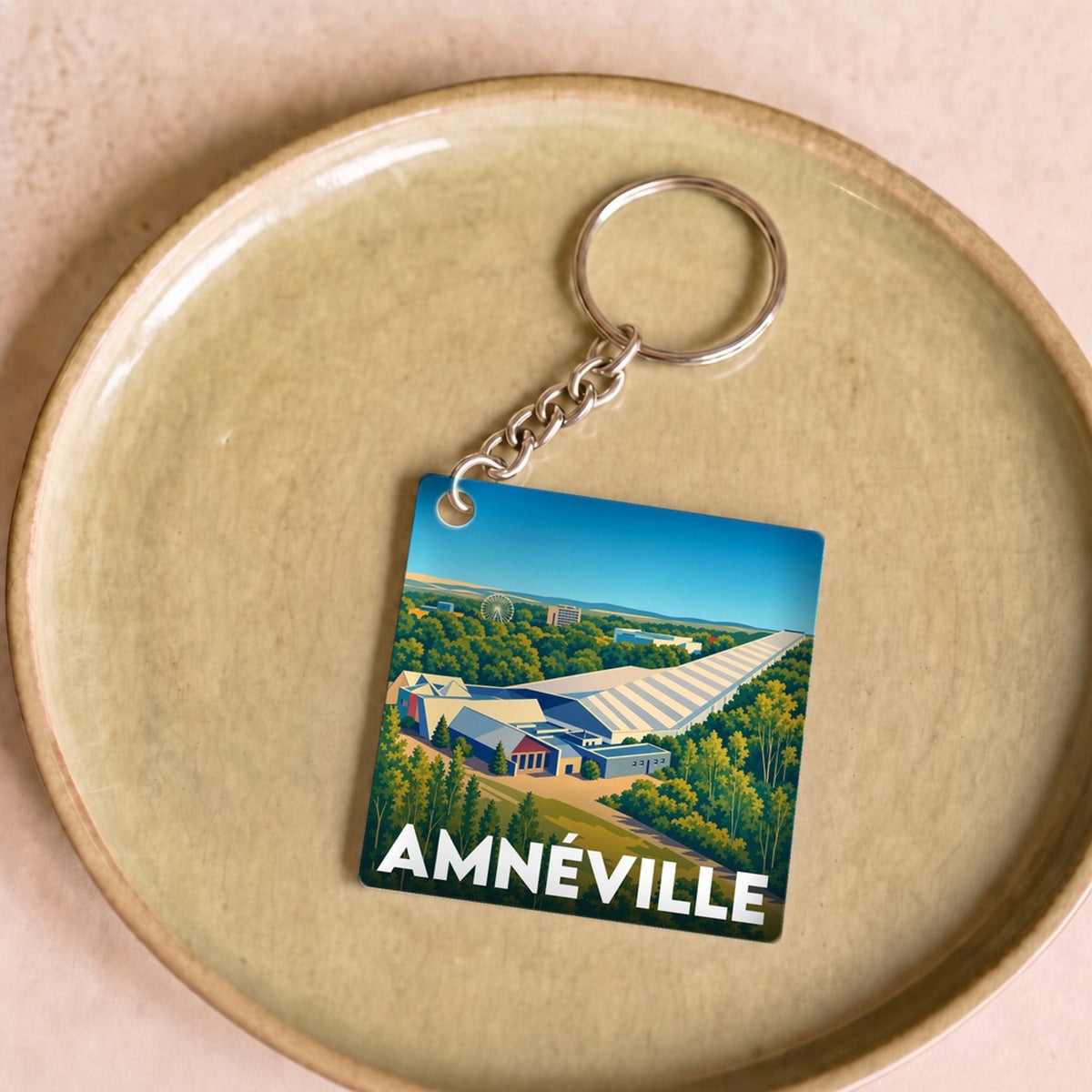 Porte-clés souvenir de la ville d'Amnéville avec une illustration stylisée de son paysage.