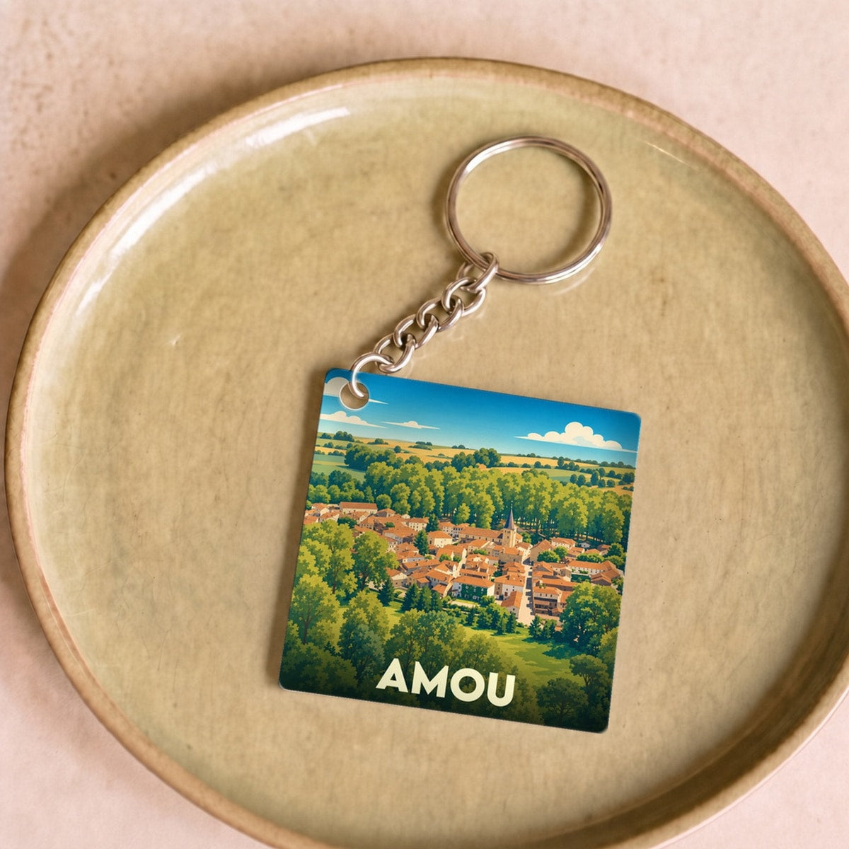 Porte-clés souvenir de la ville d'Amou avec une illustration stylisée.