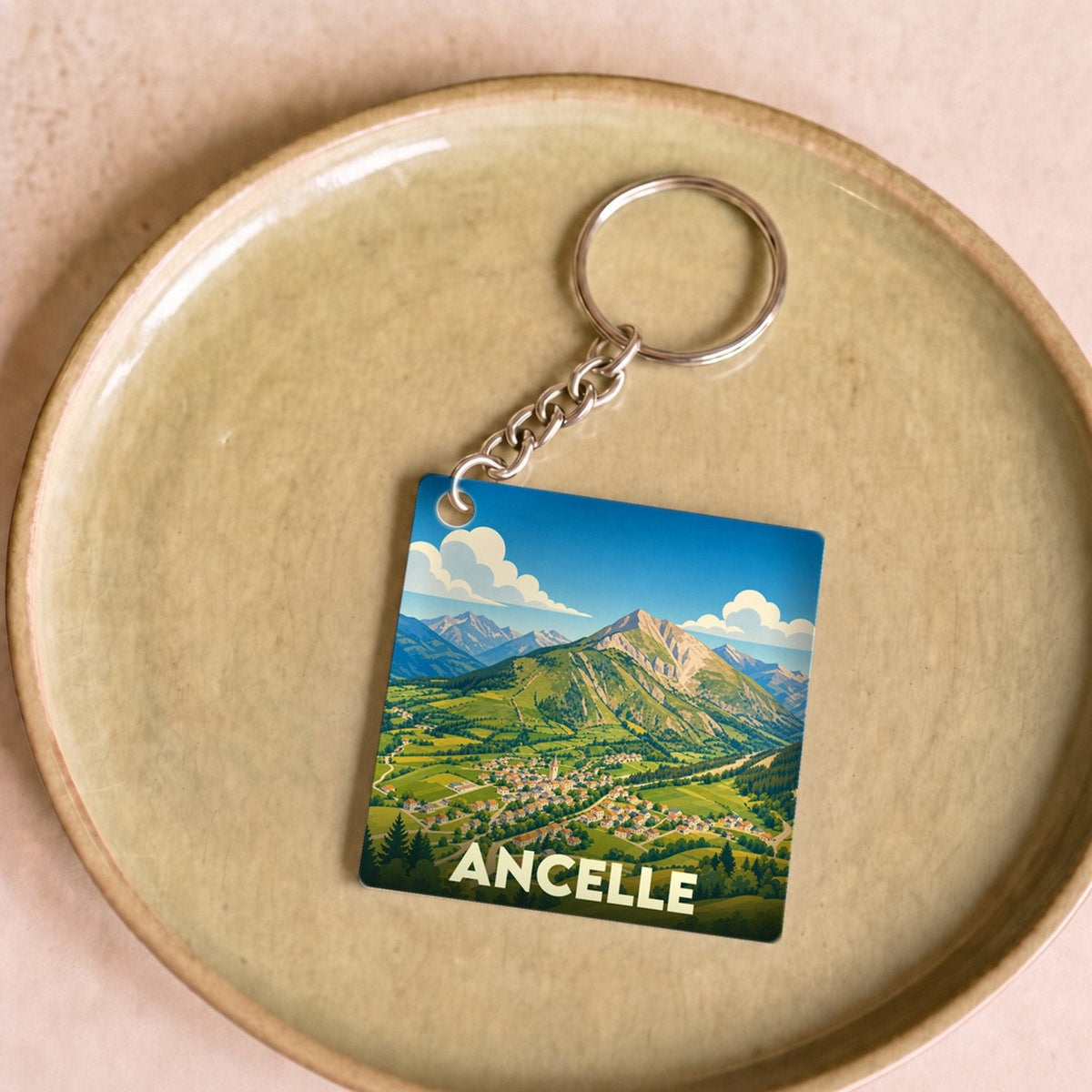 Porte-clés souvenir de la ville d'Ancelle avec une illustration stylisée de ses paysages montagneux.