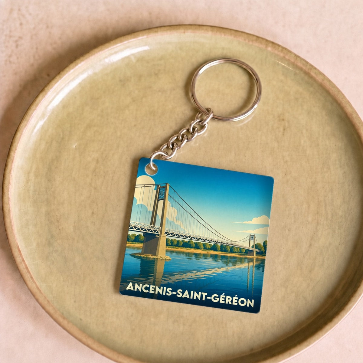 Porte-clés souvenir de la ville d'Ancenis-Saint-Géréon illustrant son pont suspendu dans un style graphique épuré.