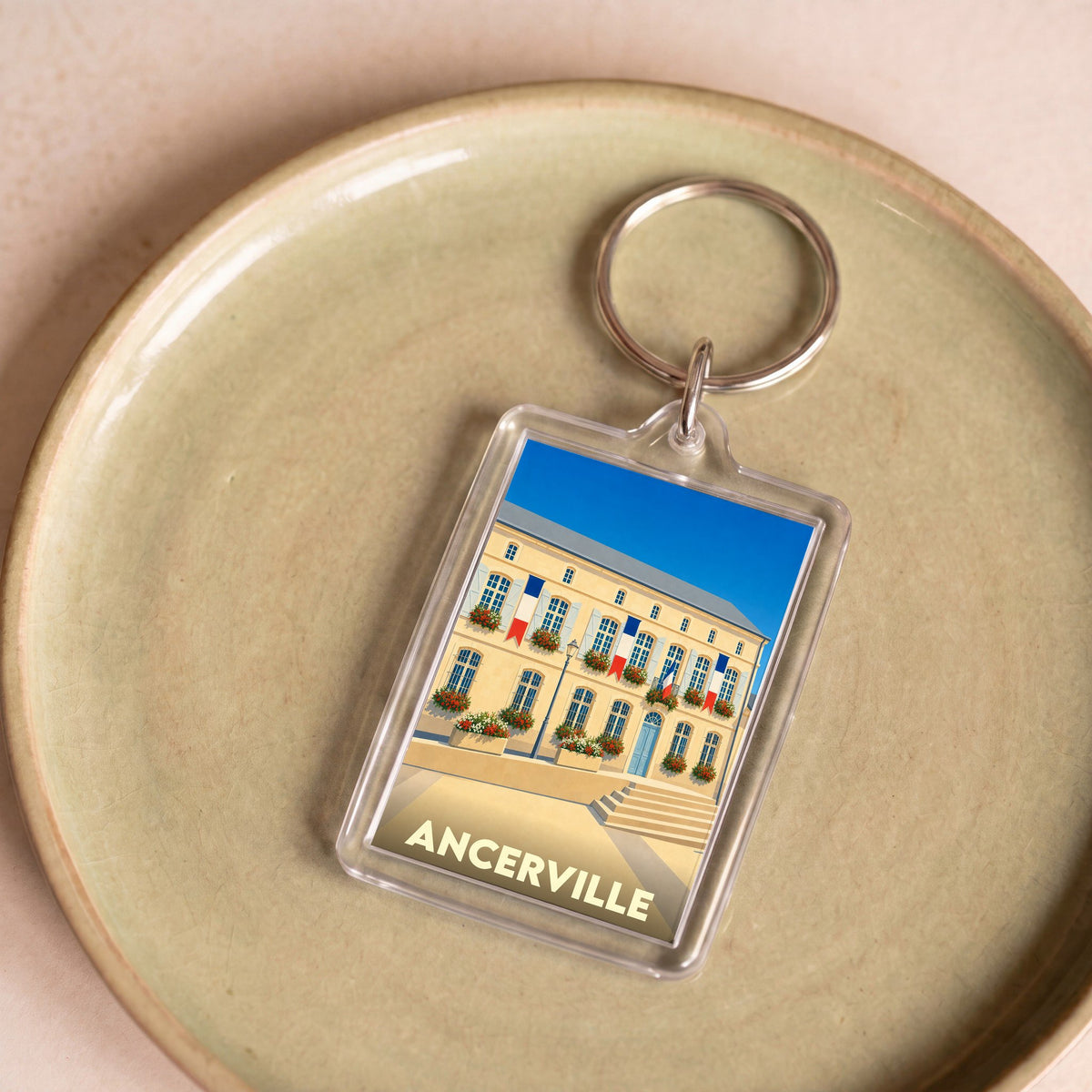 Porte-clés souvenir de la ville d'Ancerville avec une illustration stylisée de sa mairie.