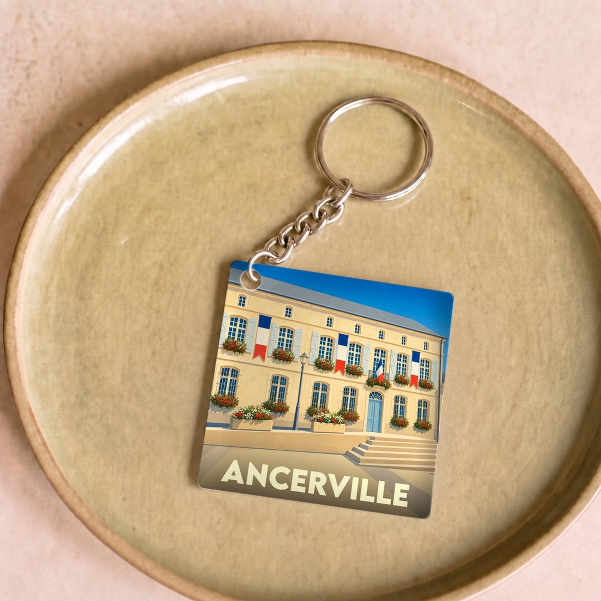 Porte-clés souvenir de la ville d'Ancerville avec une illustration stylisée de sa mairie.