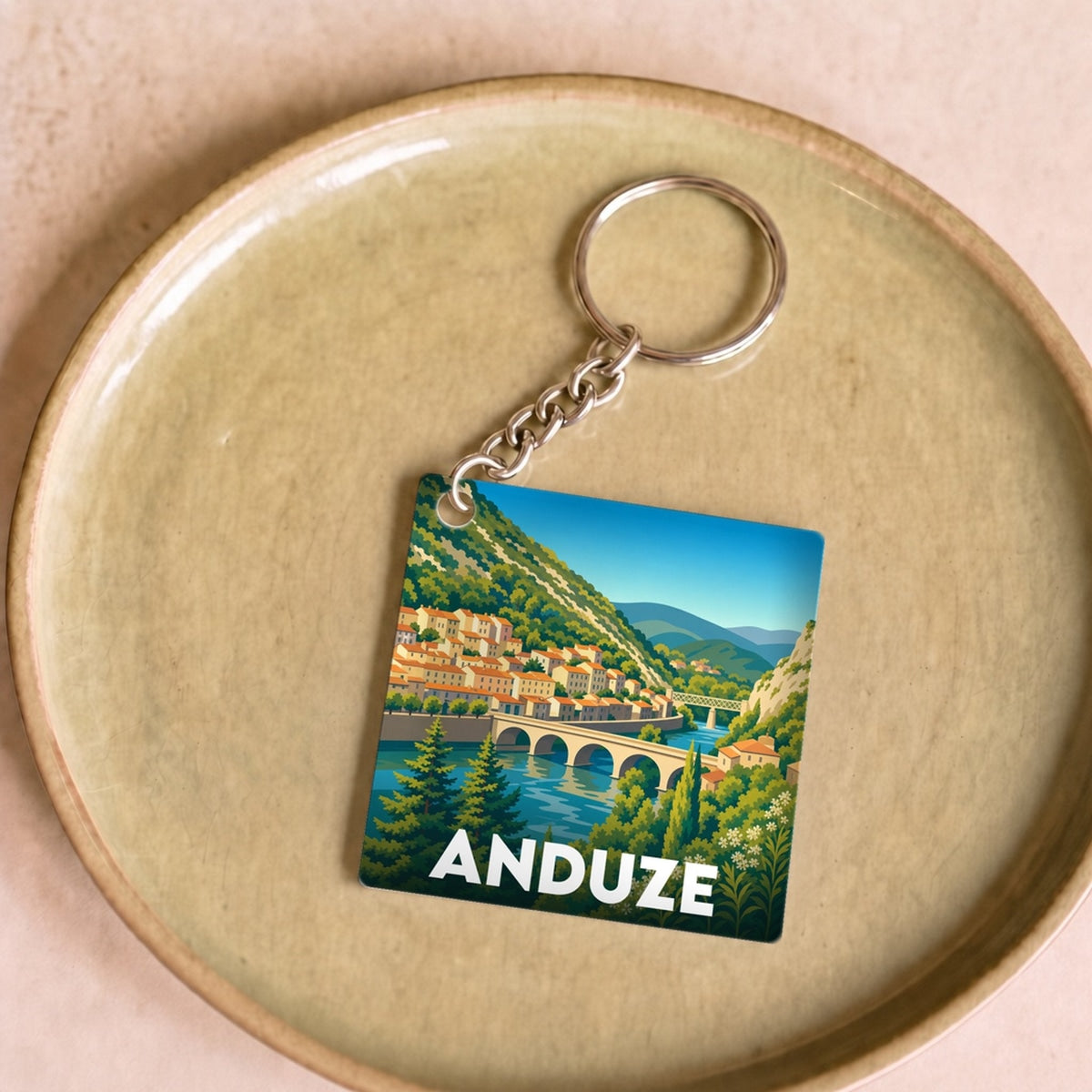 Porte-clés souvenir de la ville d'Anduze avec une illustration stylisée.
