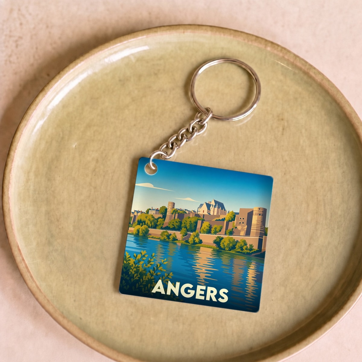 Porte-clés souvenir de la ville d'Angers avec une illustration stylisée du château et de la Maine.