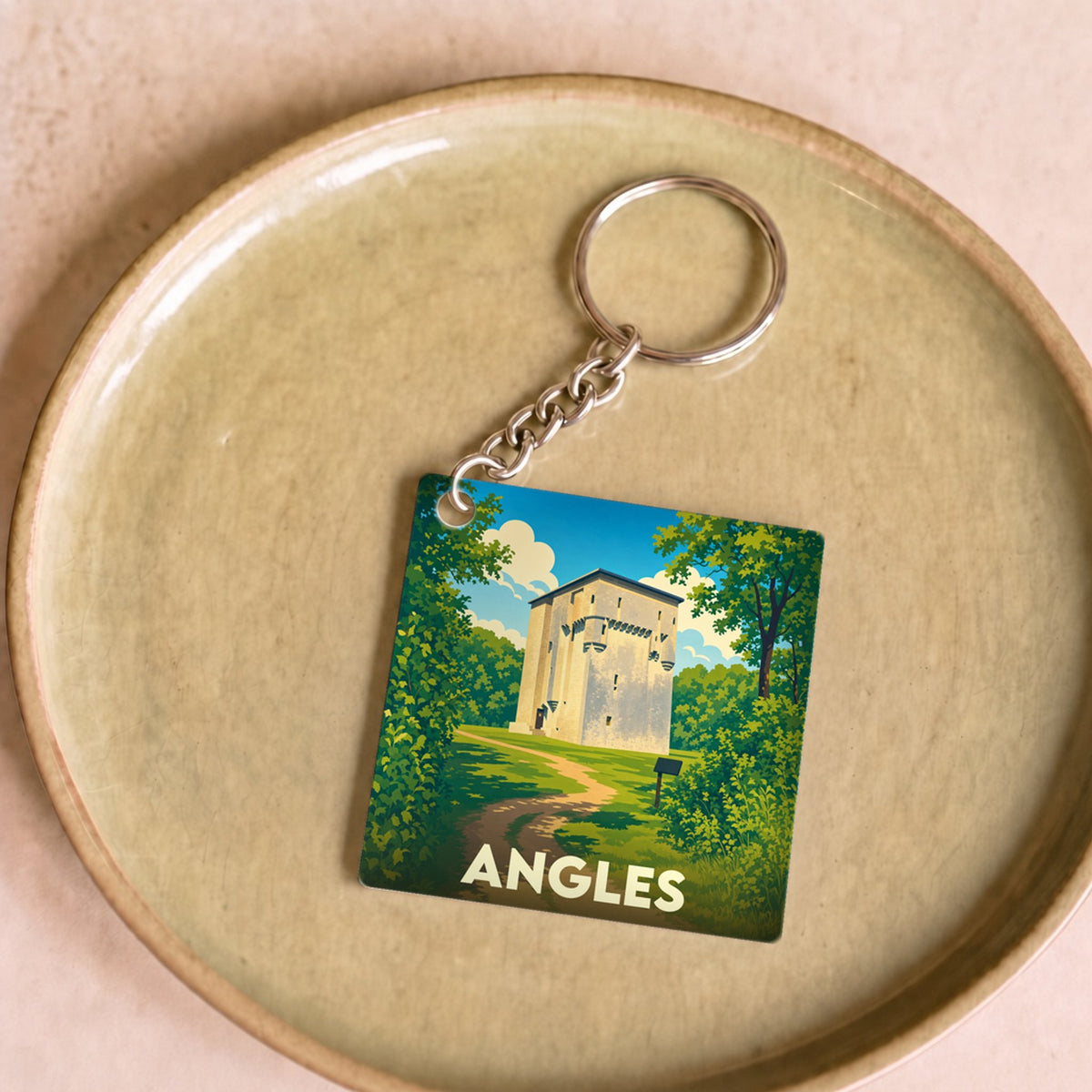 Porte-clés souvenir de la ville d'Angles avec une illustration stylisée d'un monument historique dans un paysage verdoyant.