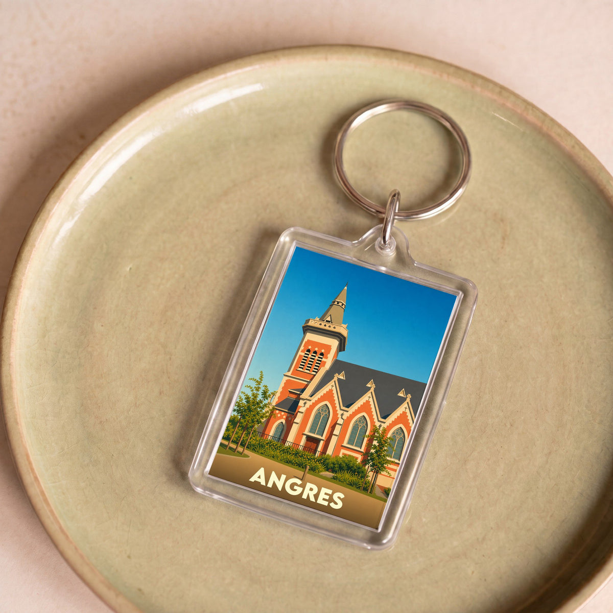 Porte-clés souvenir de la ville d'Angres avec une illustration stylisée de son église.