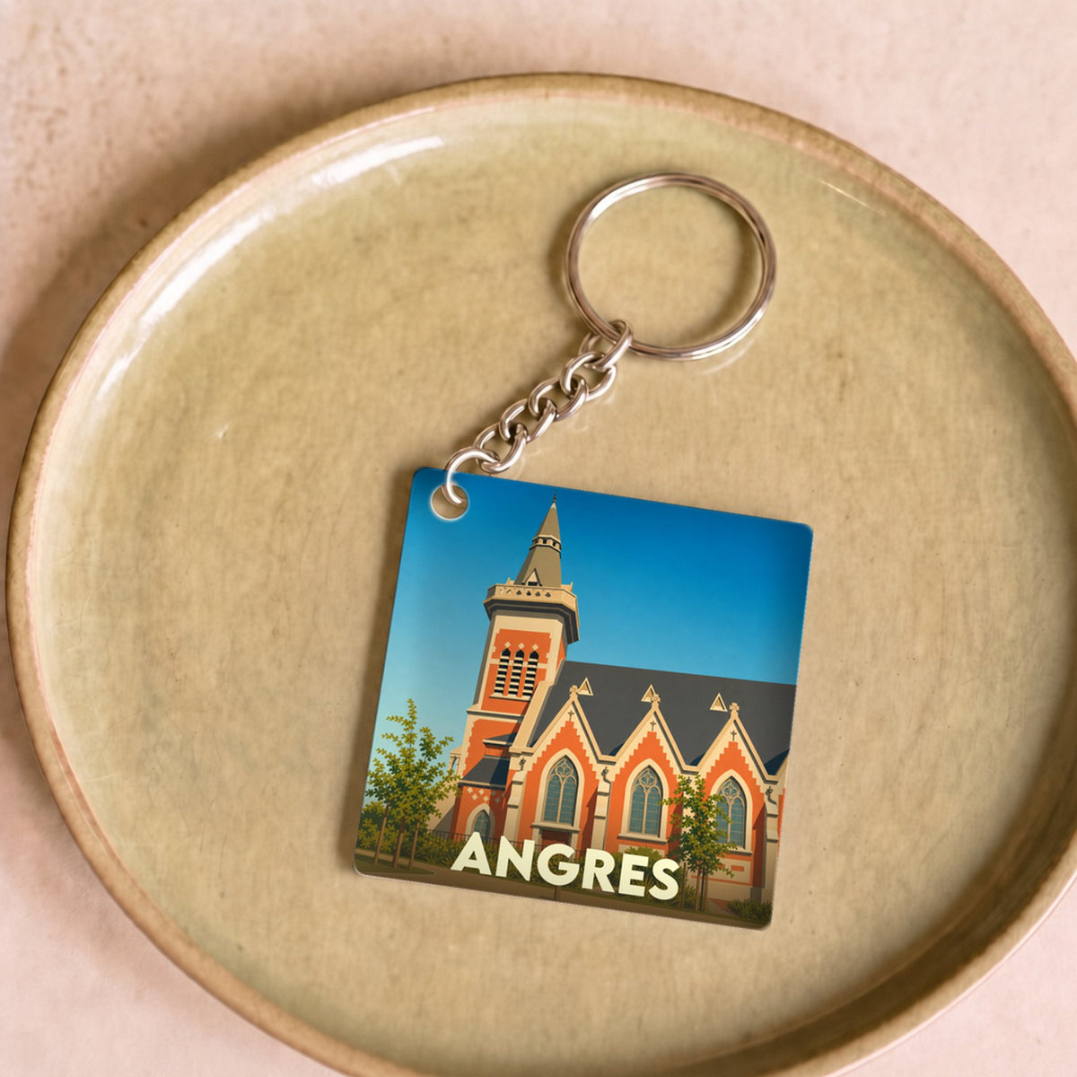 Porte-clés souvenir de la ville d'Angres avec une illustration stylisée de son église.