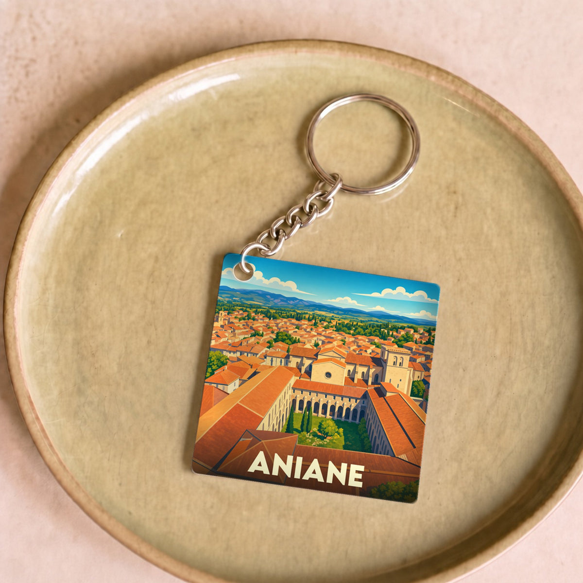 Porte-clés souvenir de la ville d'Aniane avec une illustration stylisée.