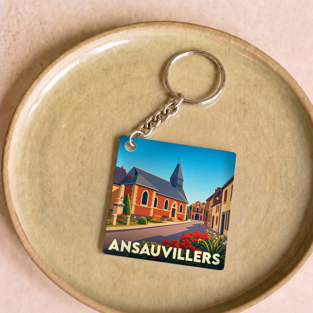 Porte-clés souvenir de la ville d’Ansauvillers avec une illustration stylisée.