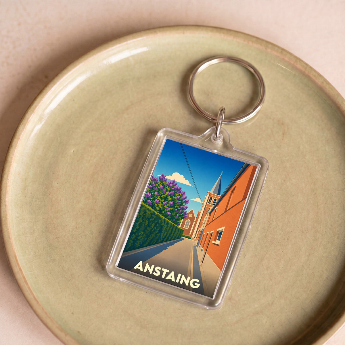 Porte-clés souvenir de la ville d'Anstaing avec une illustration stylisée.