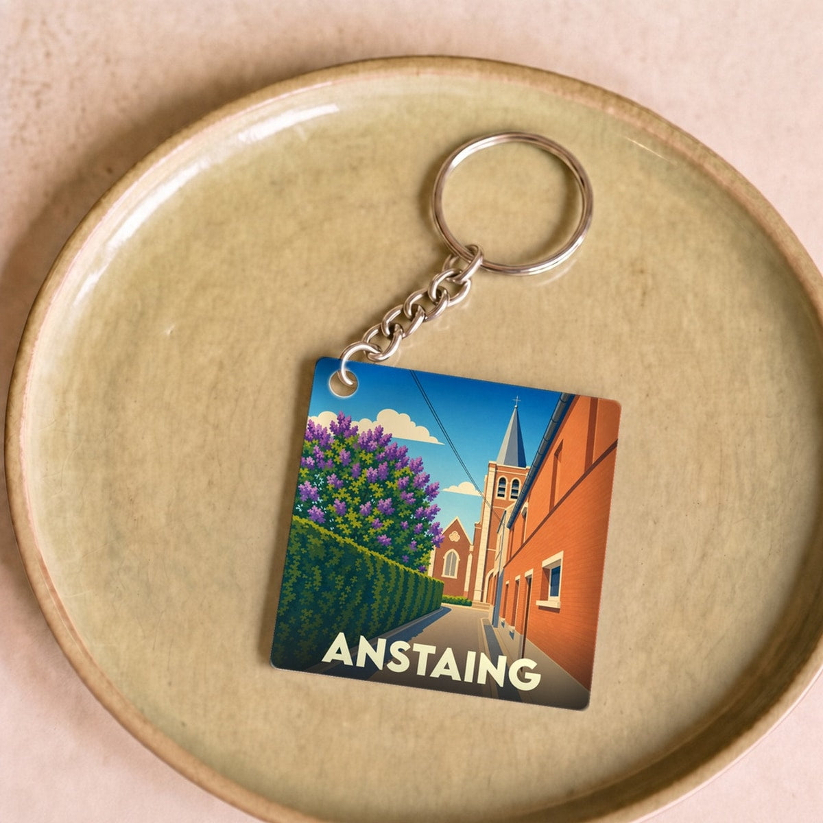 Porte-clés souvenir de la ville de Anstaing avec une illustration stylisée.