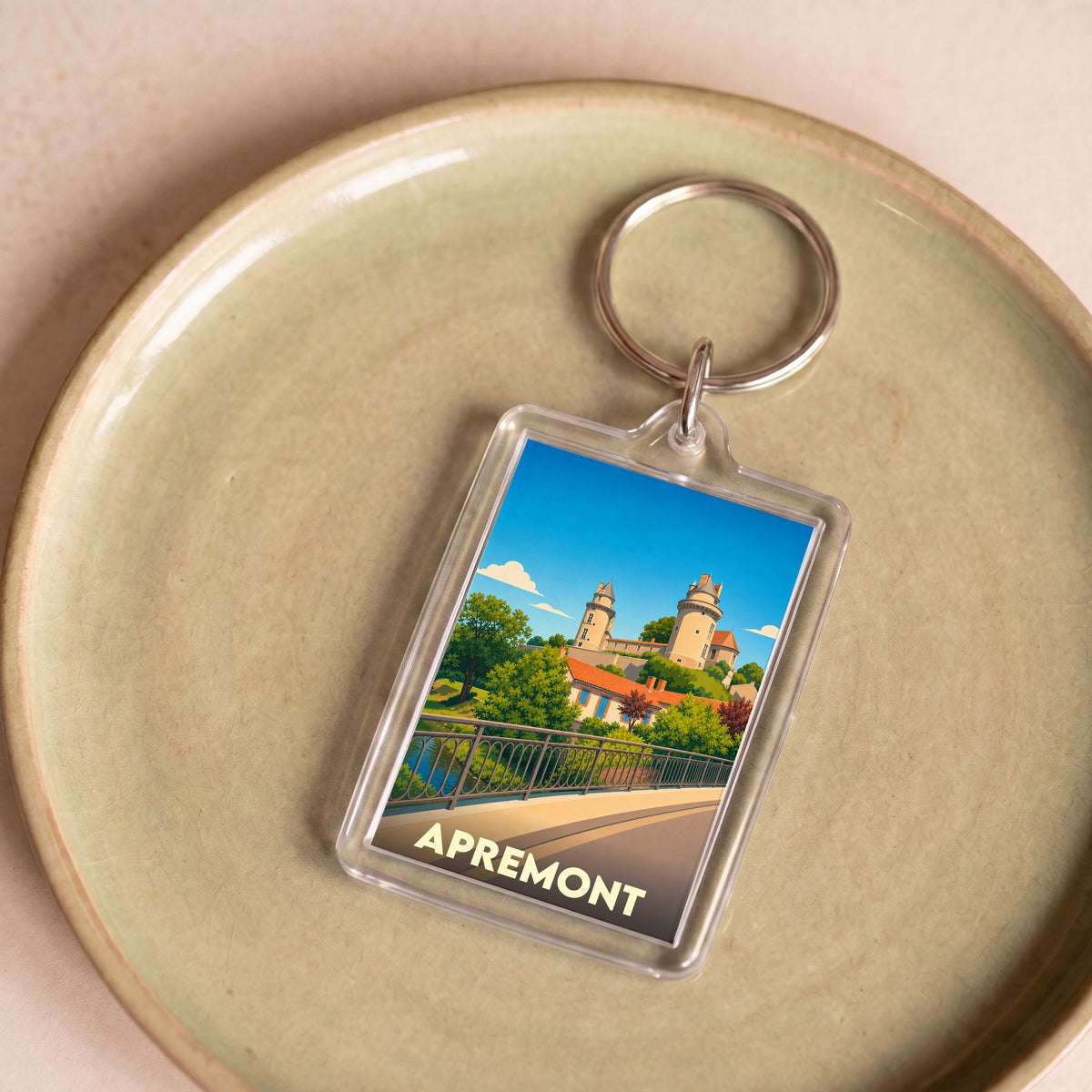 Porte-clés souvenir de la ville d'Apremont avec une illustration stylisée de son château.