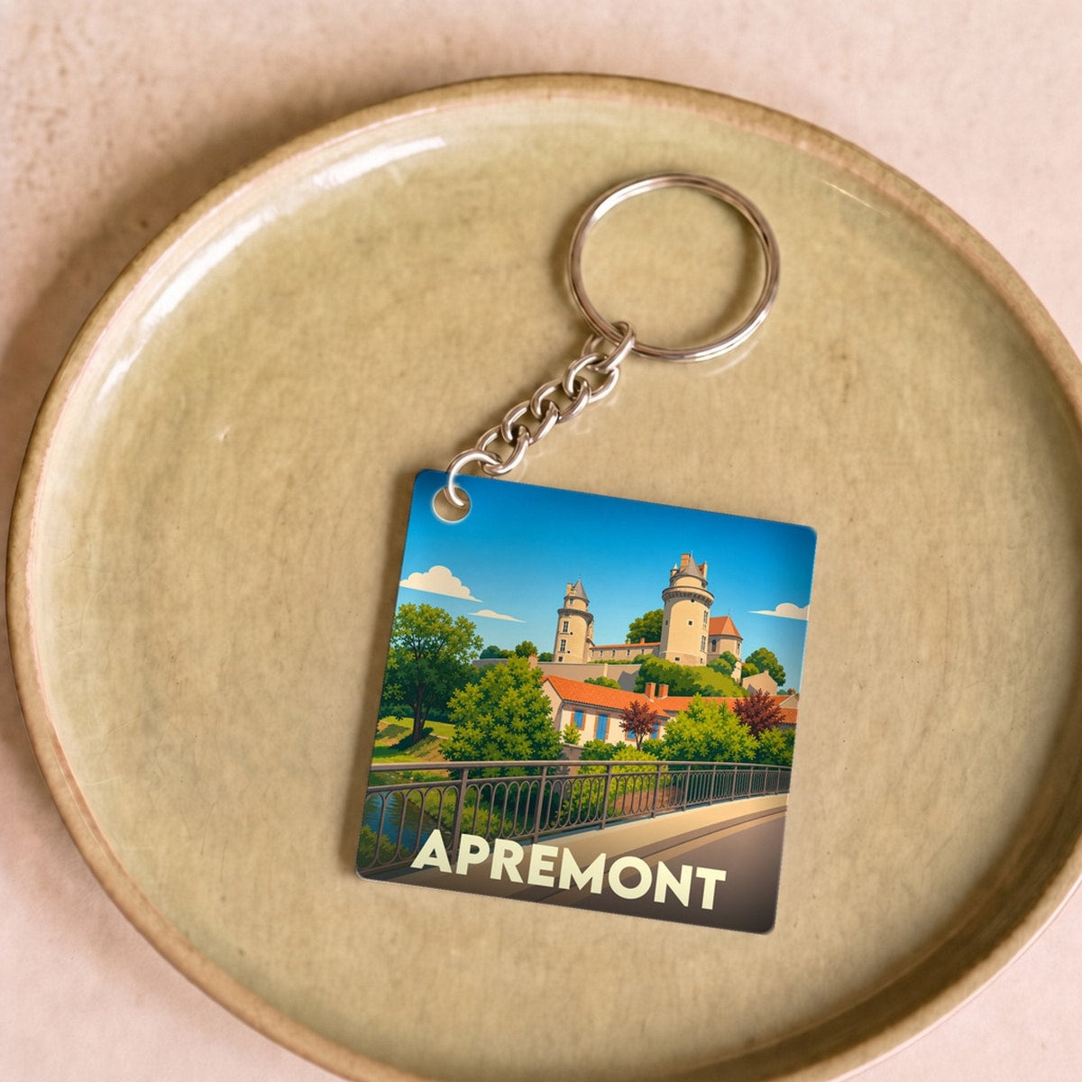 Porte-clés souvenir de la ville d'Apremont avec une illustration stylisée de son château.