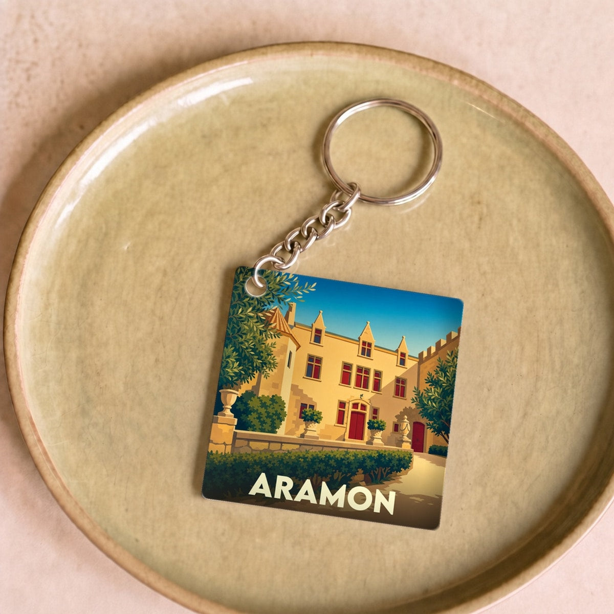 Porte-clés souvenir de la ville d'Aramon avec une illustration stylisée de son château.