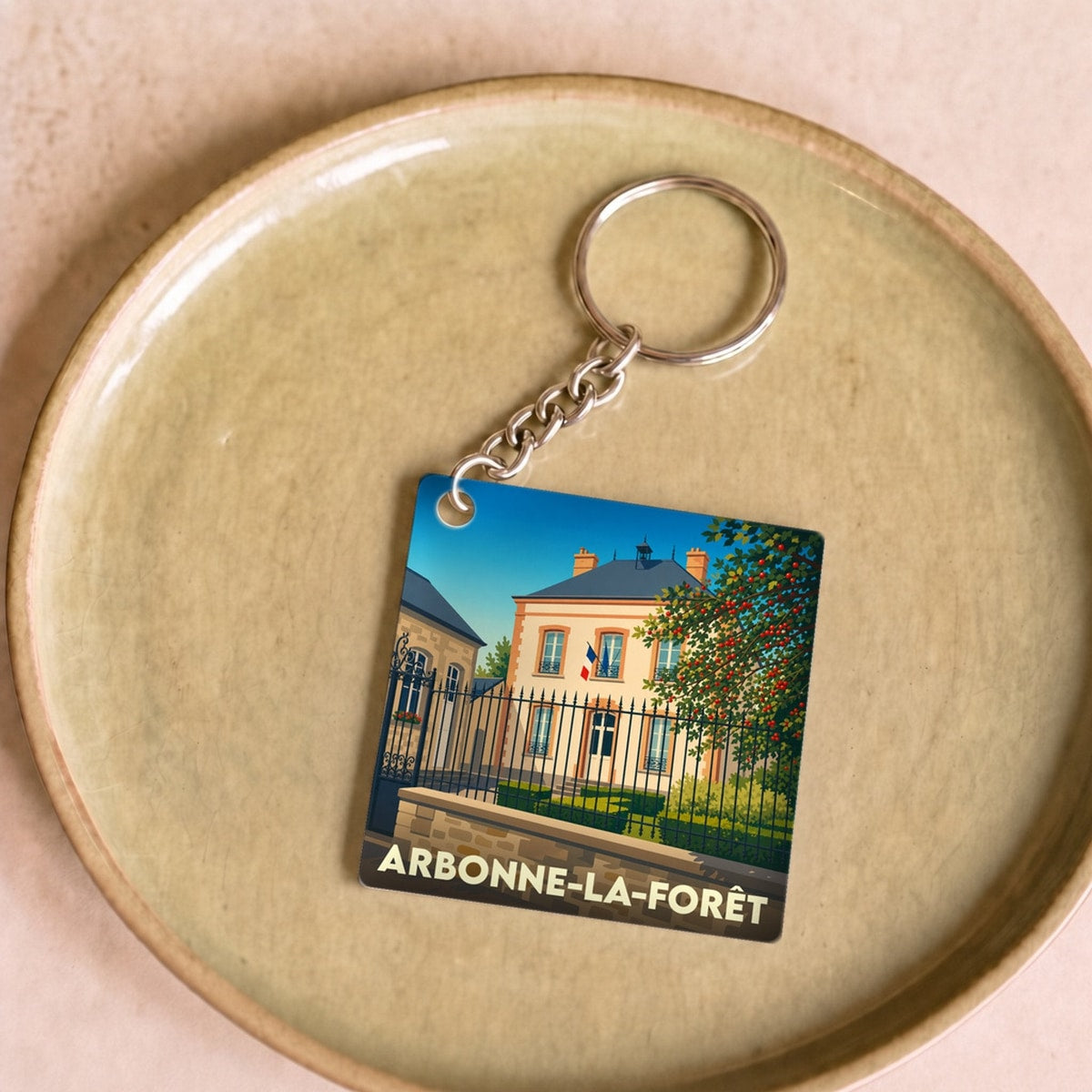 Porte-clés souvenir de la ville de Arbonne-la-Forêt avec une illustration stylisée.