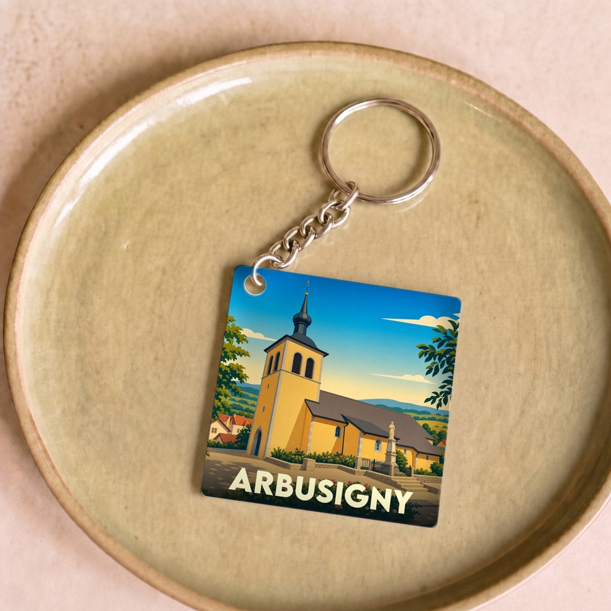 Porte-clés souvenir de la ville d'Arbusigny avec une illustration stylisée de son église.