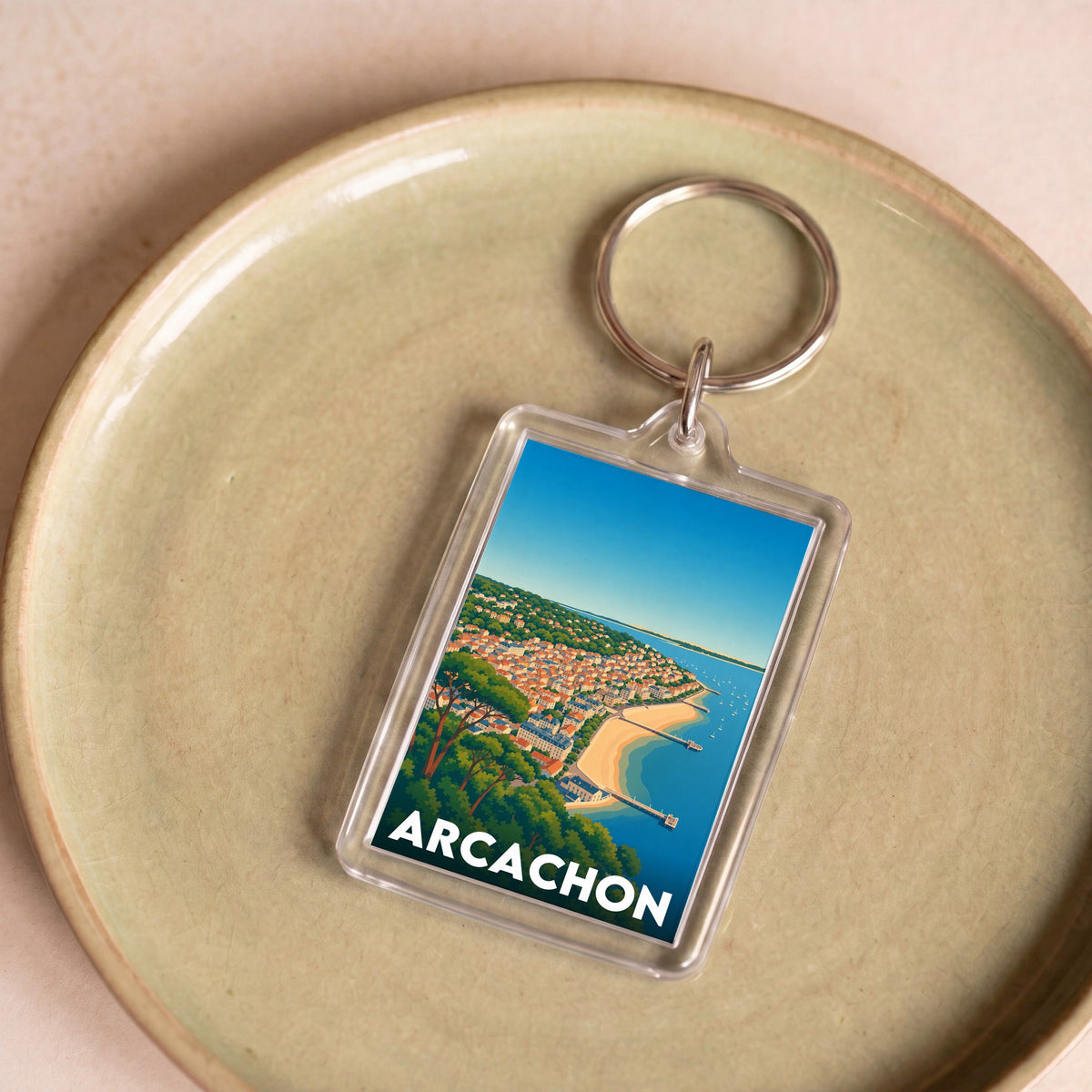 Porte-clés souvenir de la ville d'Arcachon avec une illustration stylisée du front de mer.