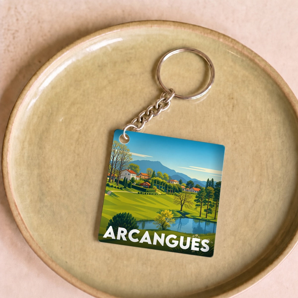 Porte-clés souvenir de la ville d'Arcangues avec une illustration stylisée de son paysage.