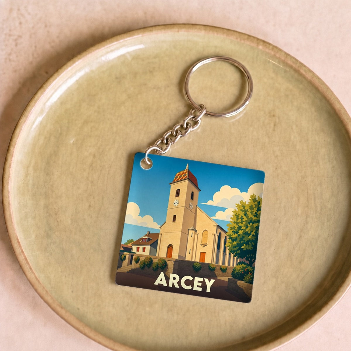 Porte-clés souvenir de la ville de Arcey avec une illustration stylisée de son église.