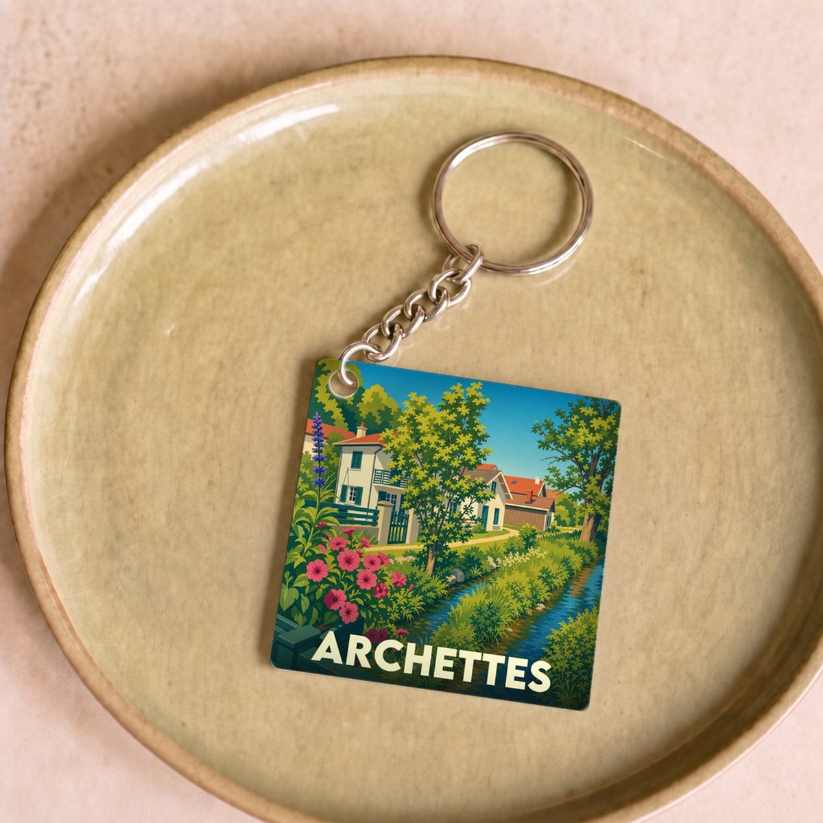Porte-clés souvenir de la ville d'Archettes avec une illustration colorée et bucolique.