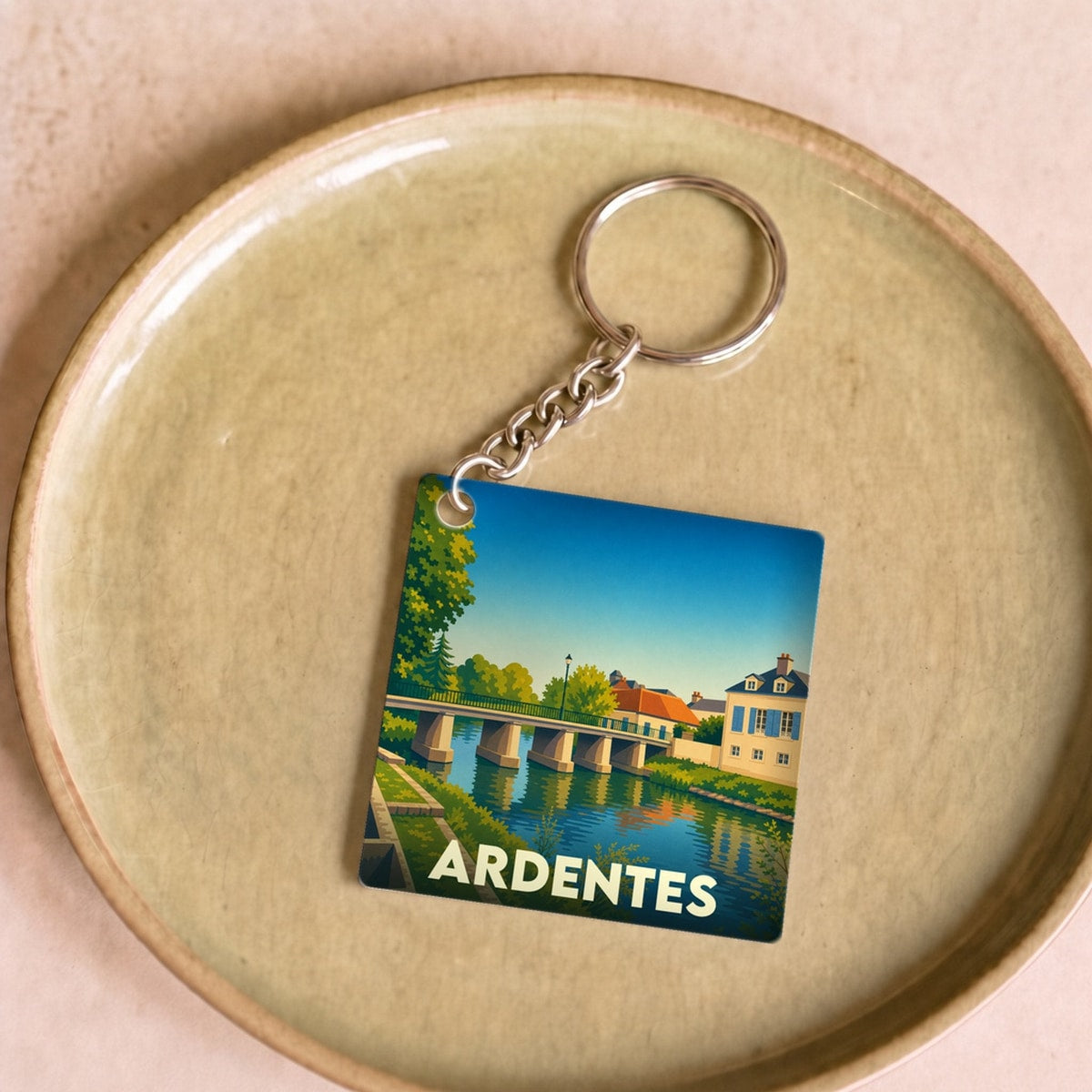 Porte-clés souvenir de la ville d'Ardentes avec une illustration stylisée d'un pont et d'une rivière.
