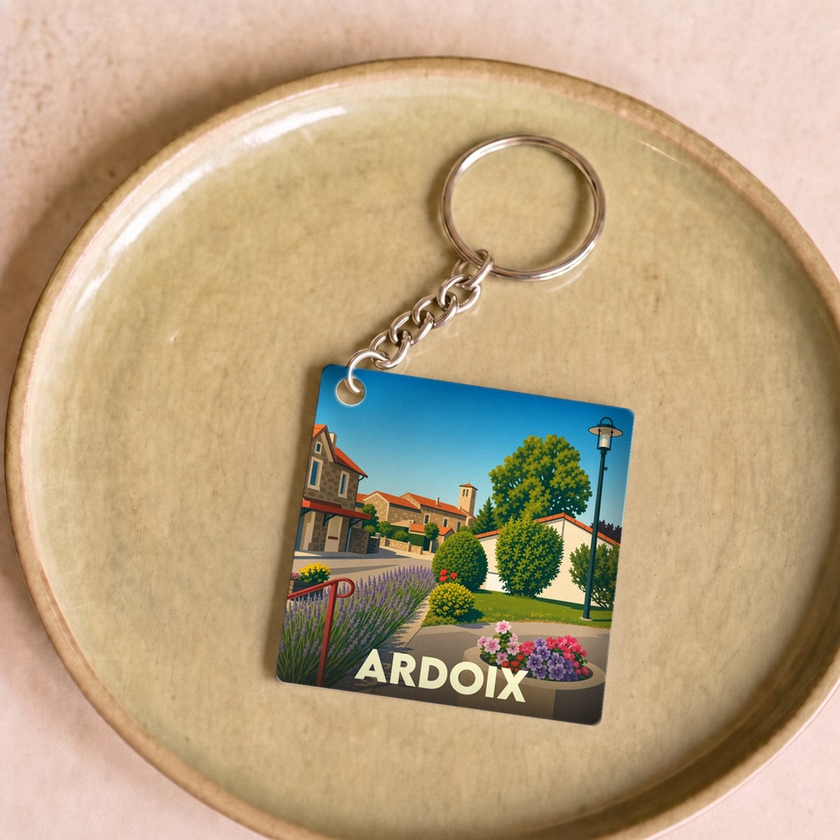 Porte-clés souvenir de la ville d'Ardoix avec une illustration stylisée de son paysage urbain.