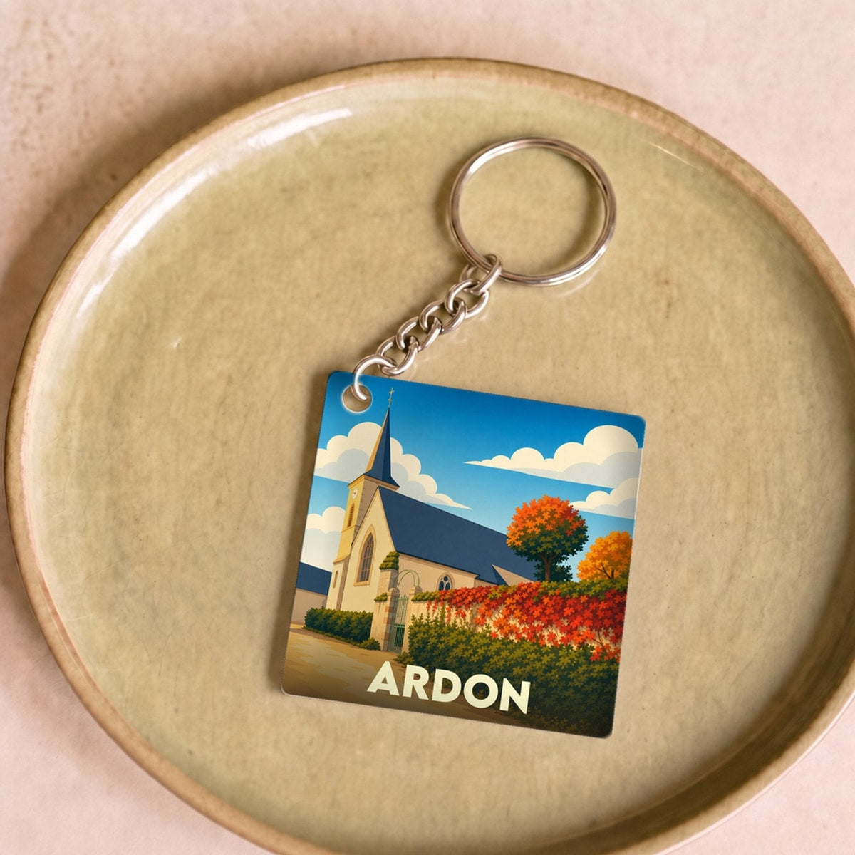Porte-clés souvenir de la ville de Ardon avec une illustration stylisée de son église.