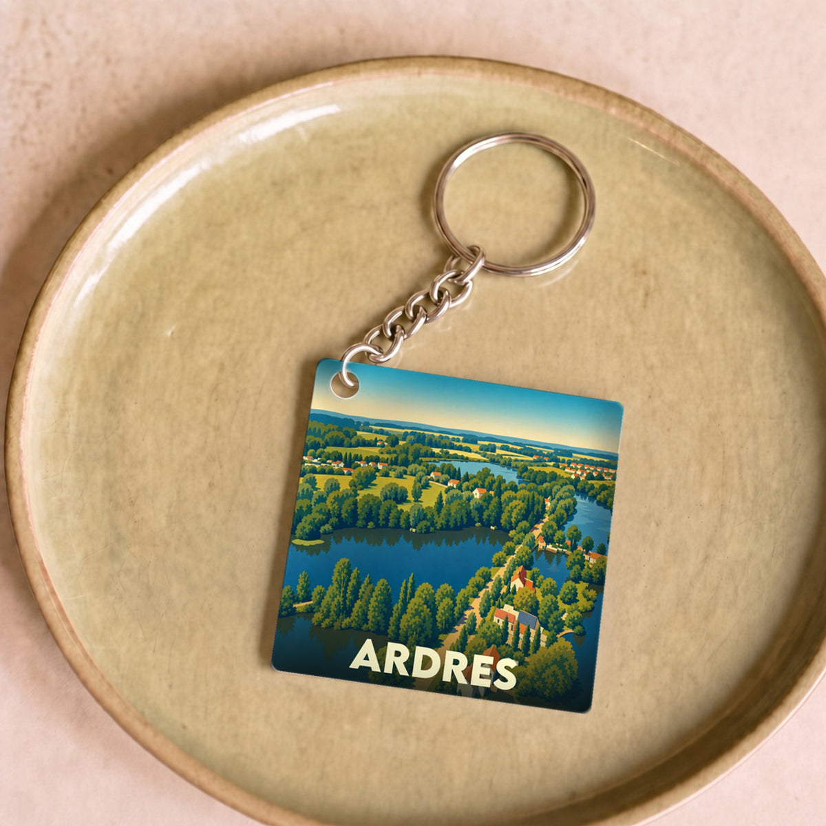 Porte-clés souvenir de la ville de Ardres avec une illustration stylisée de ses paysages et plans d'eau.