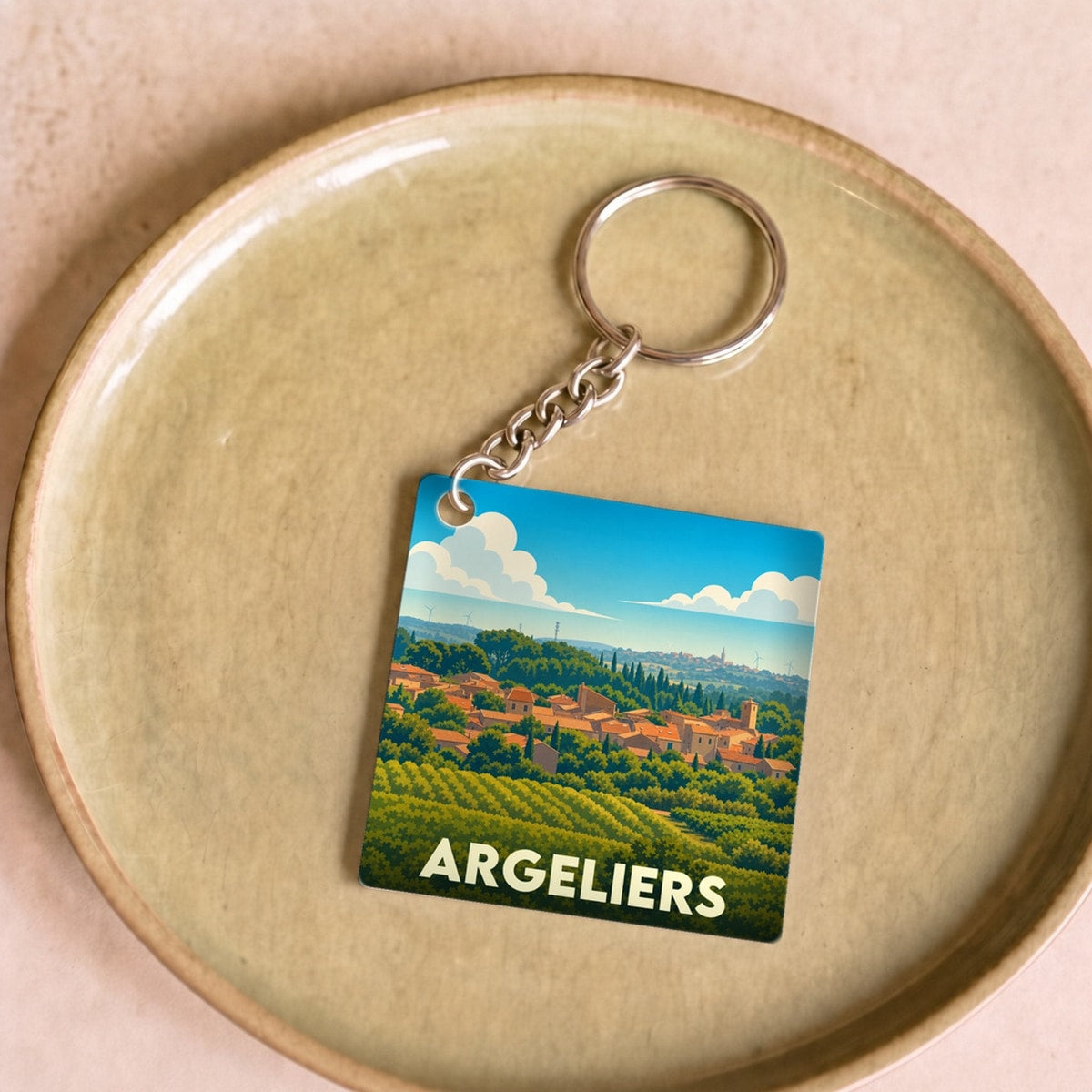 Porte-clés souvenir de la ville d'Argeliers avec une illustration stylisée de son paysage vallonné.