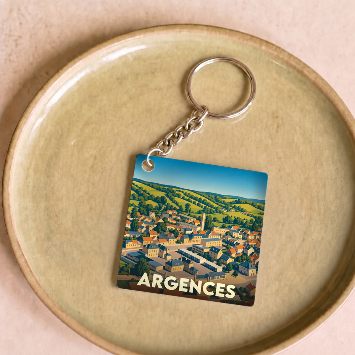 Porte-clés souvenir de la ville d'Argences avec une illustration stylisée.