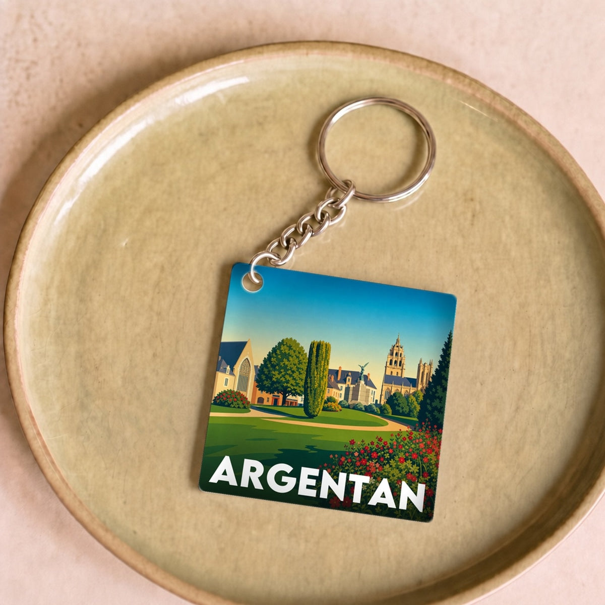 Porte-clés souvenir de la ville d'Argentan avec une illustration paysagère stylisée.