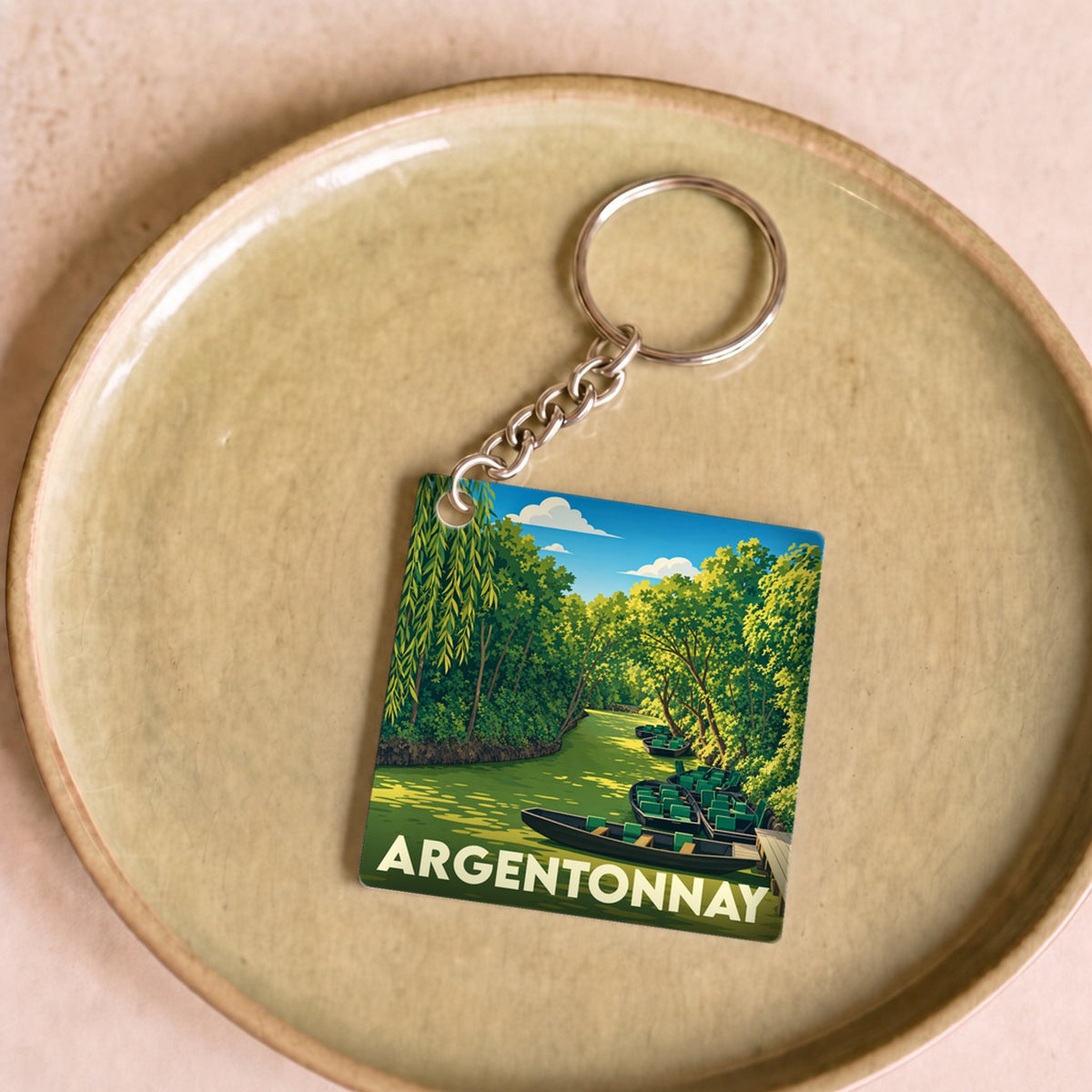 Porte-clés souvenir de la ville d'Argentonnay avec une illustration stylisée d'une rivière bordée de verdure.