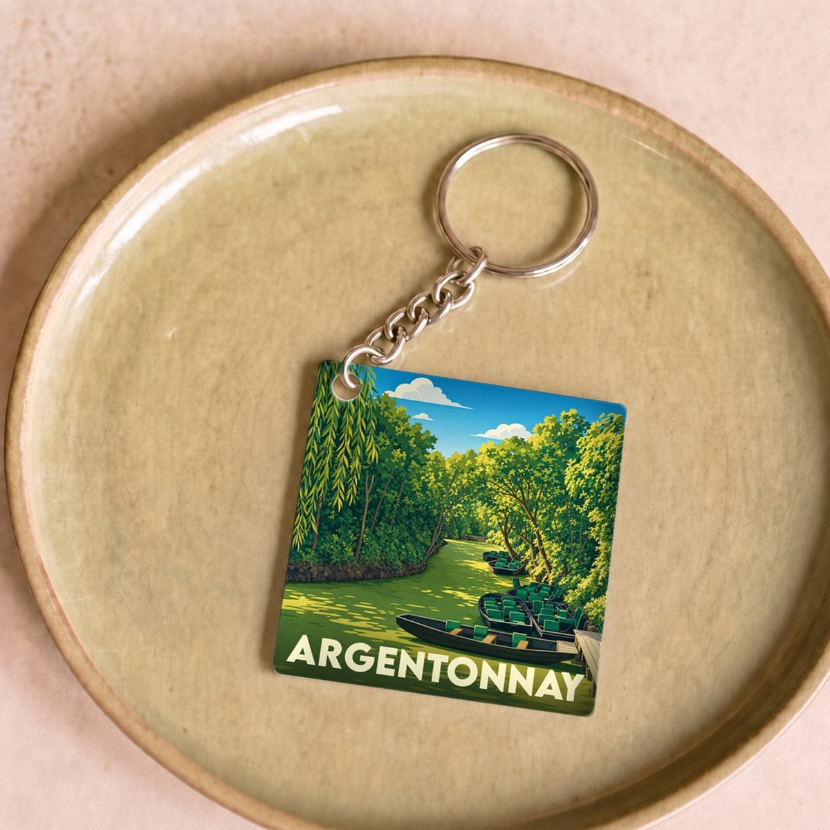 Porte-clés souvenir de la ville d'Argentonnay avec une illustration stylisée d'une rivière bordée de verdure.